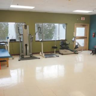 A gym interior with exercise equipment and workout machines.