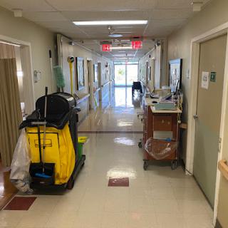 A hallway in a hospital featuring cleaning equipment, showcasing the routine maintenance of healthcare environments.