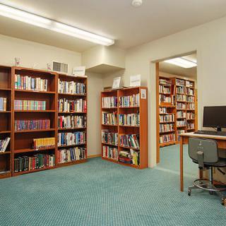 A quiet library corner with bookshelves and a computer workstation.