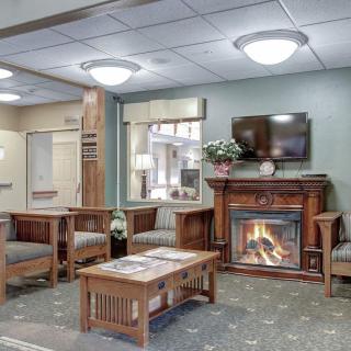Cozy lobby area with a fireplace, seating, and a television.