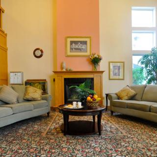 A cozy living room with two sofas, a central coffee table, and a fireplace adorned with decorative art pieces.
