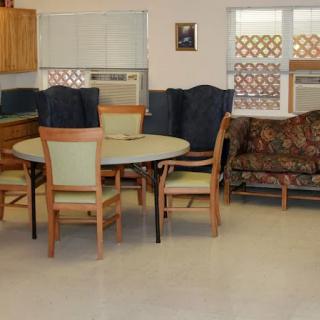 A cozy dining area with a table, chairs, and a couch.