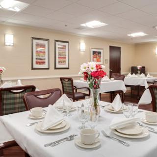 An elegantly arranged dining area featuring a formal table setting with flowers and tasteful decor.