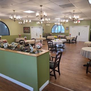 A well-lit dining area featuring elegant chandeliers and neatly arranged tables.