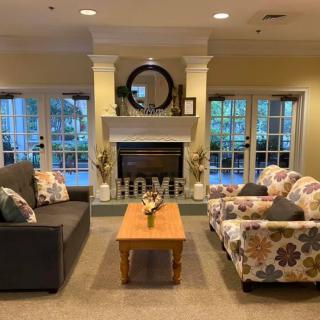 A cozy living room features a fireplace, sofa, armchair, and coffee table with elegant home decor.