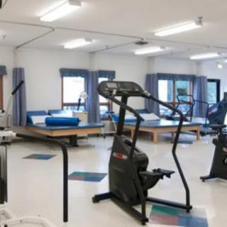 A rehabilitation center gym with various exercise equipment.