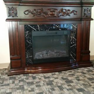 An ornate wooden fireplace with a dark marble surround.