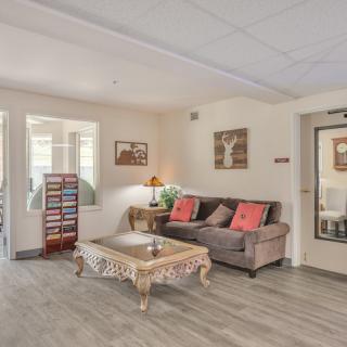A cozy living room with a comfortable sofa and an ornate coffee table, decorated with stylish artwork and a warm lamp.