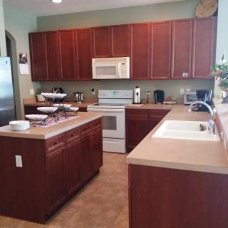A modern kitchen with wooden cabinets and various appliances.