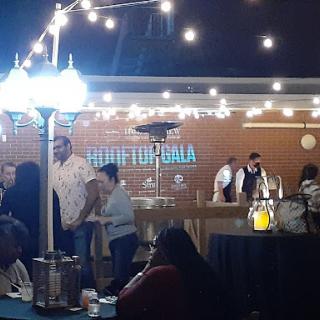A lively outdoor event with decorative lights and a bar setup, creating a festive atmosphere.