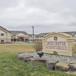Entrance to a residential facility named 'Hidden Waters' with landscaped surroundings.