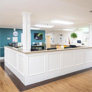 A modern reception area with a central desk and bright lighting.