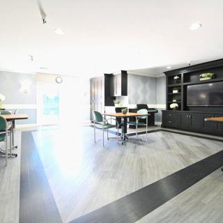 A modern, minimalist room with sleek furniture and a geometric wooden floor.