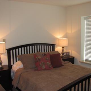 Cozy bedroom with a neatly made bed and soft lighting.