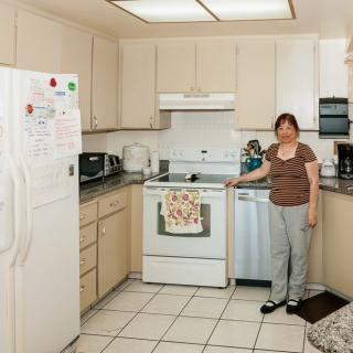 A woman standing in a kitchen with modern appliances.