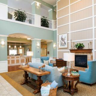 A spacious and elegantly designed living room featuring modern furniture and a cozy fireplace.