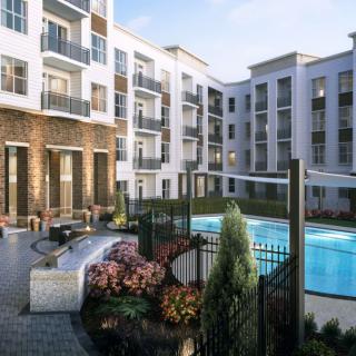 A modern apartment complex with a pool and landscaped outdoor area.