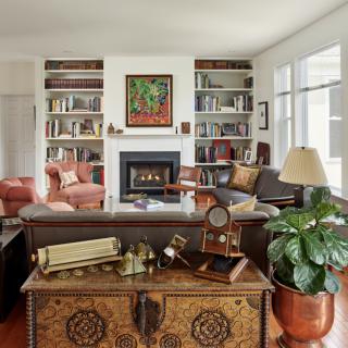 A cozy living room featuring bookshelves, a fireplace, and comfortable seating.