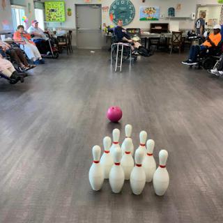 Residents engaging in a fun game of bowling at a community center.