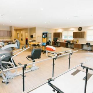 A spacious physical therapy center equipped with various exercise machines and rehabilitation equipment.