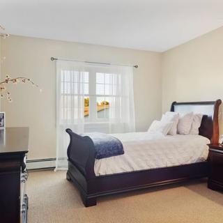 A cozy and well-lit bedroom with elegant furniture and a large window.