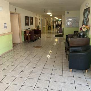 A hallway with tiled floors and seating areas along the sides.