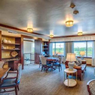 A modern living room with ample natural light, featuring comfortable seating and stylish decor.