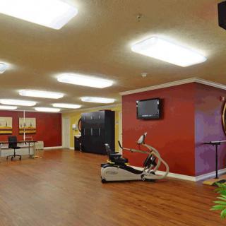 A modern gym interior featuring exercise equipment and vibrant red walls.