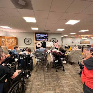 Residents of an assisted living facility gather for an activity in a communal area.