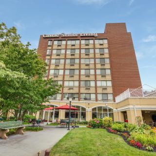 A view of a hotel building surrounded by greenery and a pathway.