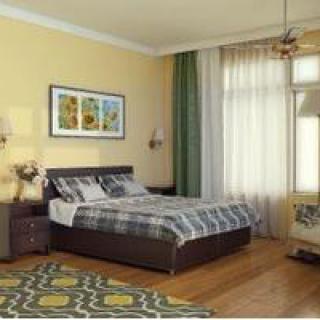 A cozy bedroom with stylish decor, featuring a bed, artwork, and large windows with curtains.