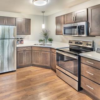 A modern kitchen with stainless steel appliances and wood cabinets.
