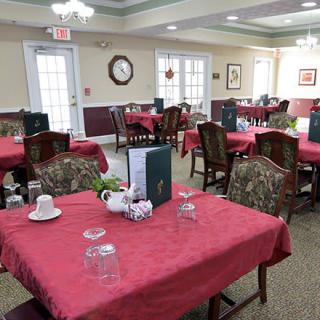 An elegant dining area with red tablecloths and neatly arranged tables and chairs.