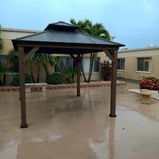 A gazebo in a courtyard, with wet pavement after rain.