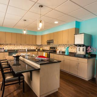 A modern and stylish kitchen featuring a blue accent wall and an island counter, perfect for cooking and dining.