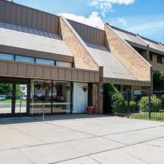 A commercial building with a modern architectural design and an entrance shaded by overhangs.