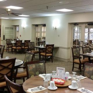 An indoor dining area with arranged tables and chairs, ready for guests.