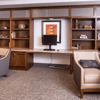 A well-organized office space with bookshelves, a desk, and comfortable chairs.