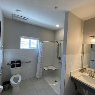A modern, accessible bathroom with a walk-in shower and safety grab bars.