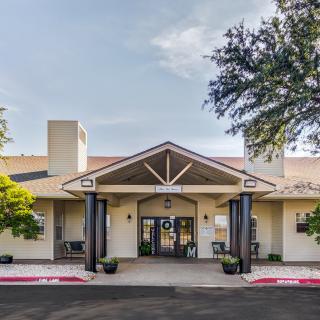 A front view of a building with a welcoming entrance and surrounding trees.