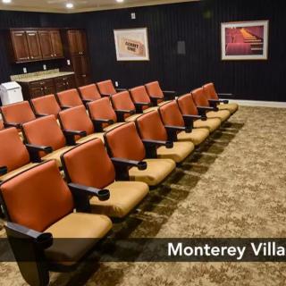 A cozy indoor theater room with rows of orange and beige seating.