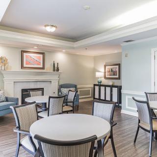 A cozy living room with a fireplace, round table, and chairs.