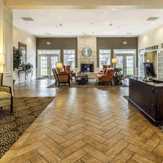 A spacious hotel lobby with elegant furnishings, featuring a seating area and a fireplace.