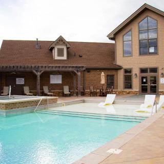 A spacious outdoor swimming pool area in front of a modern house.
