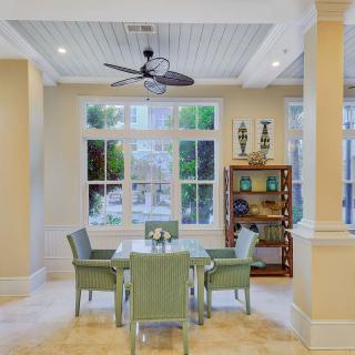 A bright and airy dining area with wicker furniture and large windows.