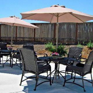 A cozy outdoor patio setup featuring chairs and umbrellas, perfect for enjoying a sunny day.