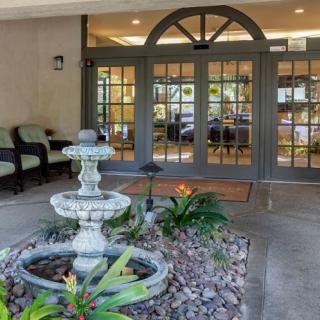 A welcoming entrance with a decorative fountain and greenery.