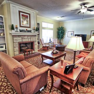 A cozy living room with comfortable seating, a fireplace, and warm lighting.