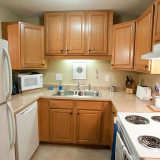 A cozy kitchen with wooden cabinets and various appliances.