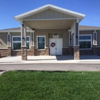 A modern community building with a well-maintained lawn and clear blue skies.